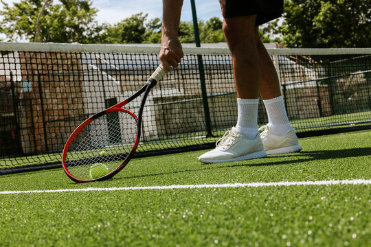 Tennis player preparing to serve on lush green court in Tulum