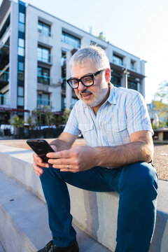 Gray-haired businessman using smartphone 