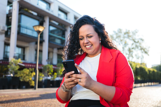 Smiling businesswoman using mobile phone in the city