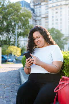 Latin businesswoman using mobile phone in the city
