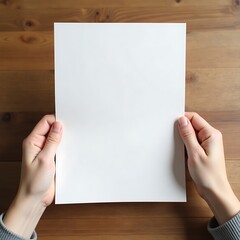 Fototapeta premium Flyer mockup held by two hands over a wooden table, showing full front view