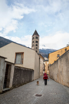Woman walks in empty historical village with her dog
