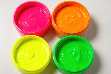 Bright neon paints in open containers pink, orange, yellow, green vivid colors