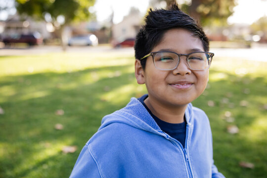 Smiling Young Boy Outdoors at Park on a Sunny Day