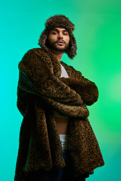 Stylish man poses in furry coat with vibrant background