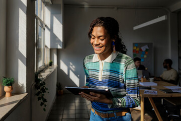 Smiling manager using digital tablet in modern office