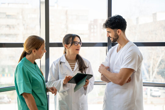 Medical team discussing patient information using tablet in hospital