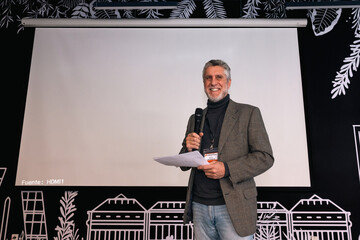 Confident speaker presenting at a seminar with a white screen
