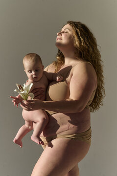 young plus size woman with her baby on a sun ray