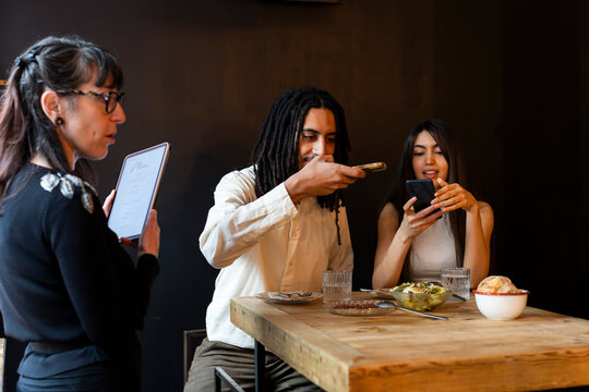 Happy Couple taking pictures of dishes in wedding menu tasting 