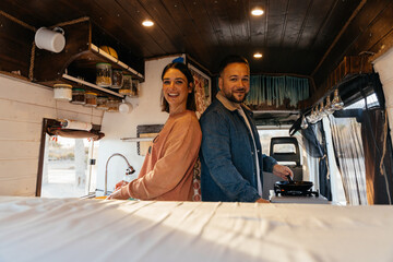 Couple cooking inside their camper van kitchen