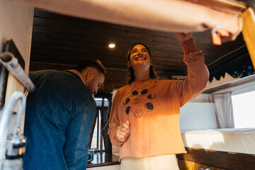 Couple renovating camper van raising roof, enjoying campervan life