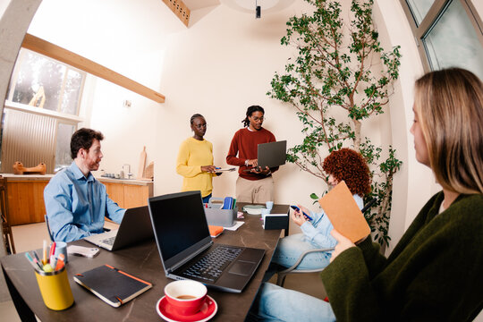 Angled view of a desk during a sales pitch in a meeting room
