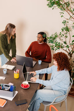 A group of professionals enthusiastically exchange ideas in a meeting