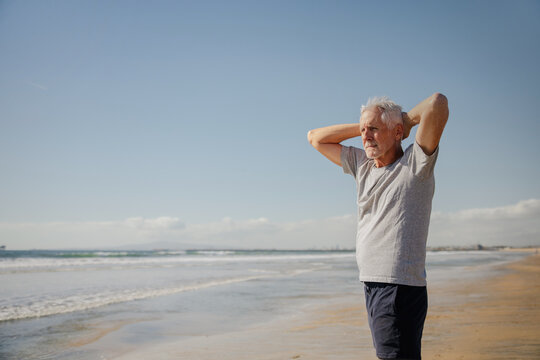 Senior Man Enjoying a Peaceful Beach Day with Thoughtful Reflection - Powered by Adobe