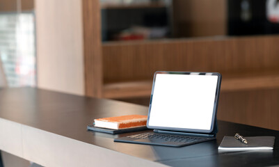 Mockup blank screen laptop computer or digital tablet with keyboard on wooden table, creative workspace.
