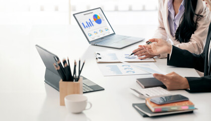 Two businesswoman working together in boardroom, brainstorming, discussing and analyzing and...
