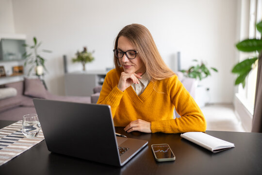 Investor analyzing data using laptop and phone indoors
