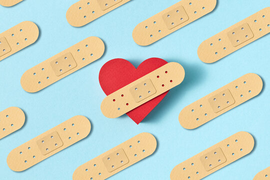 Papercraft figure of red heart with plaster strip.