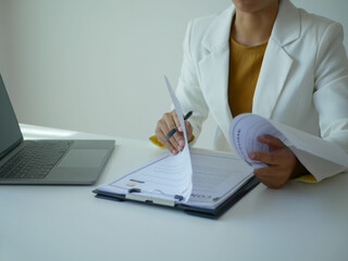 Asian businesswoman employer sitting holding new employee's documents to evaluate and review new employee's personal history. Recruitment concept, job placement