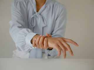 Asian business woman massaging wrist in pain Caused by working on a computer keyboard for a long...