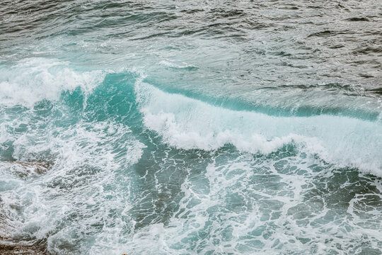 Powerful Waves Crashing Against Rocky Outcrop