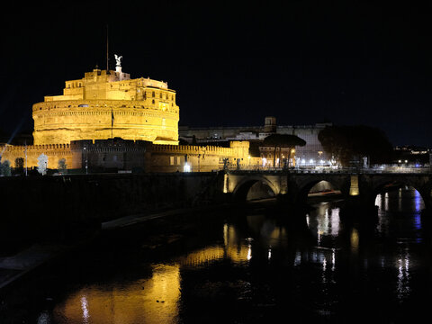 Sant Angelo castle and Tiber river at night in Rome city.