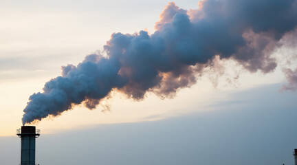 Smoke Emission from Industrial Chimney Against Sunset Sky with Colorful Clouds