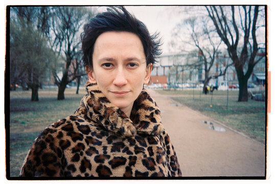 Portrait of a person in a leopard print coat on a park path