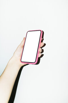 Hand holding a smartphone mobile phone with blank white mockup screen 