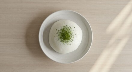 Japanese Mochi Dessert: Minimalist Top Down View - Creamy white mochi, topped with matcha powder, presented on a simple plate. Symbolizes purity, simplicity, elegance, serenity, and tradition