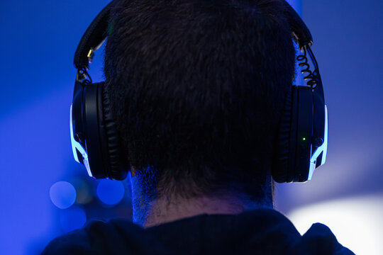 Sound engineer wearing headphones mixing music in recording studio