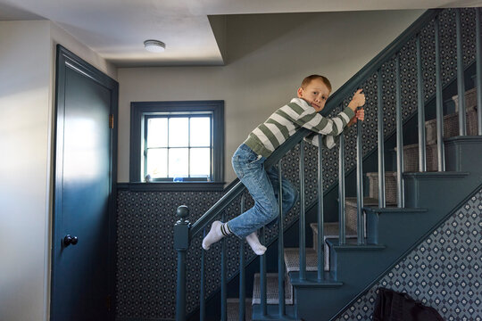 The little boy plays on the stairs at his house