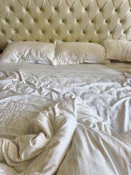 White bed sheet on a messy bed