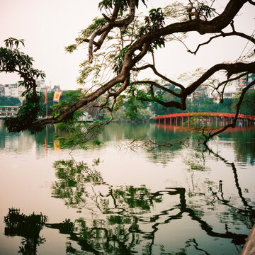 A red bridge over a small lake.