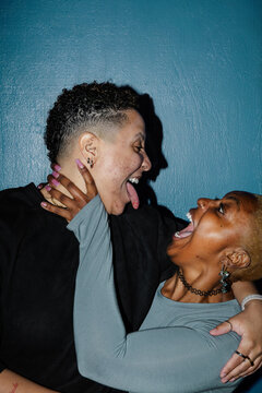 Joyful Friends Expressing Emotion Against a Vibrant Blue Background