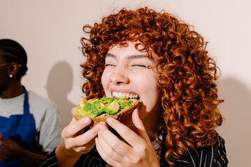 Portrait of a young woman enjoying an avocado toast