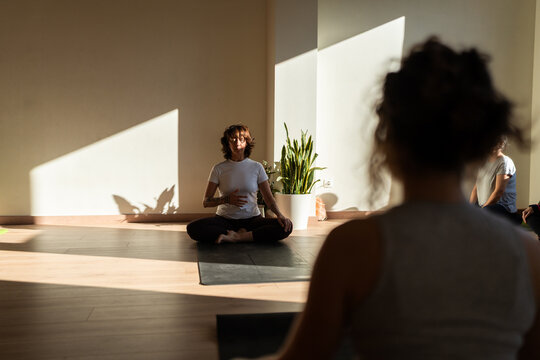 Yoga instructor guiding meditation practice during group