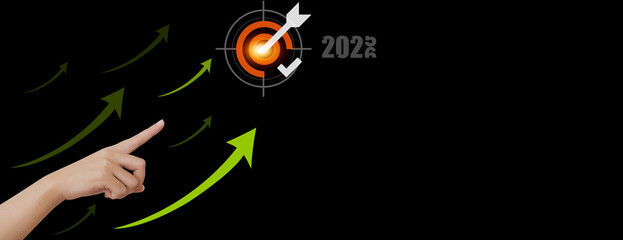 A person's hand points towards a target, symbolizing goals for 2024. The arrows pointing upwards visualize growth and progress. The backdrop is a sleek.