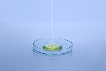 Transparent Liquid Pouring Into a Glass Petri Dish