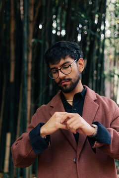 Portrait of distracted man looking at his hands.