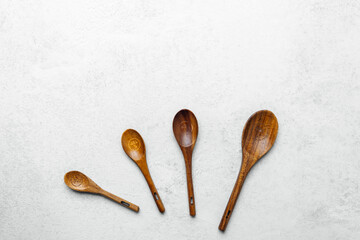 Set of four handcrafted wooden spoons on a light textured surface