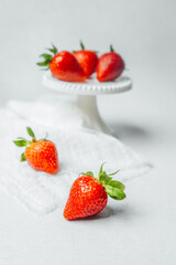 Fresh strawberries on a white table with a cake stand accent