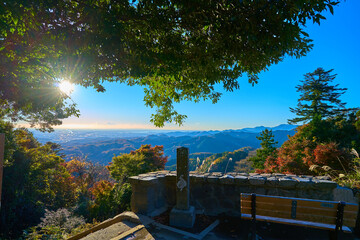 秋の東京八王子市の高尾山駅展望台付近から朝日差す都心方面を見る