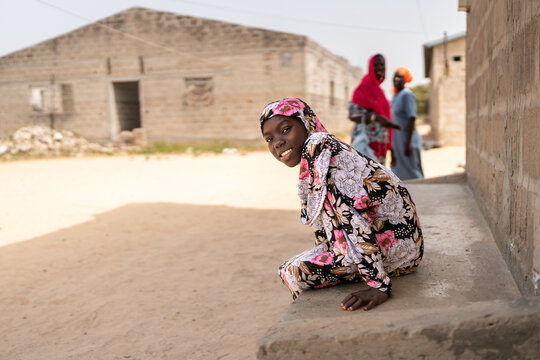 Young senegalese girl sitting and smiling in a village in Africa