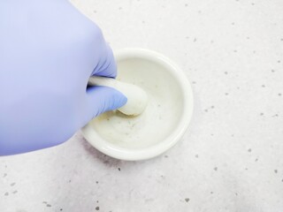 Scientists are grinding using a mortar and pestle made of porcelain
