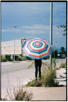 man carrying a beach umbrella on the street, 35mm