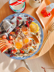 Fried eggs with spinach and mixed fruits for breakfast. Delicious food. Bruch menu. Healthy recipes. Easy home cooking. Diet food dish. High Protein. eggs recipe. Easy breakfast. Tropical fruits. 