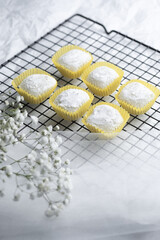 Delicate sweets arranged on a wire rack with floral accents in a bright setting