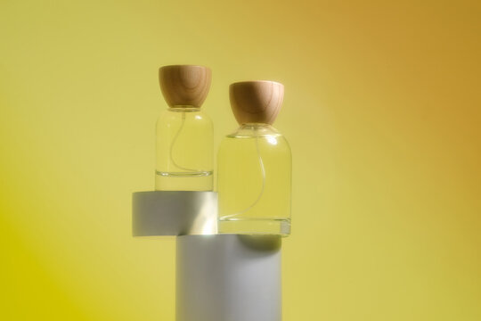 Two perfume bottles with natural wood caps on a gradient background